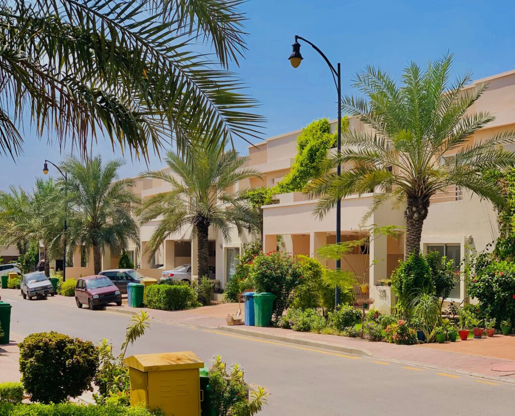 Charming residential street lined with palm trees in Karachi, showcasing modern urban living.
