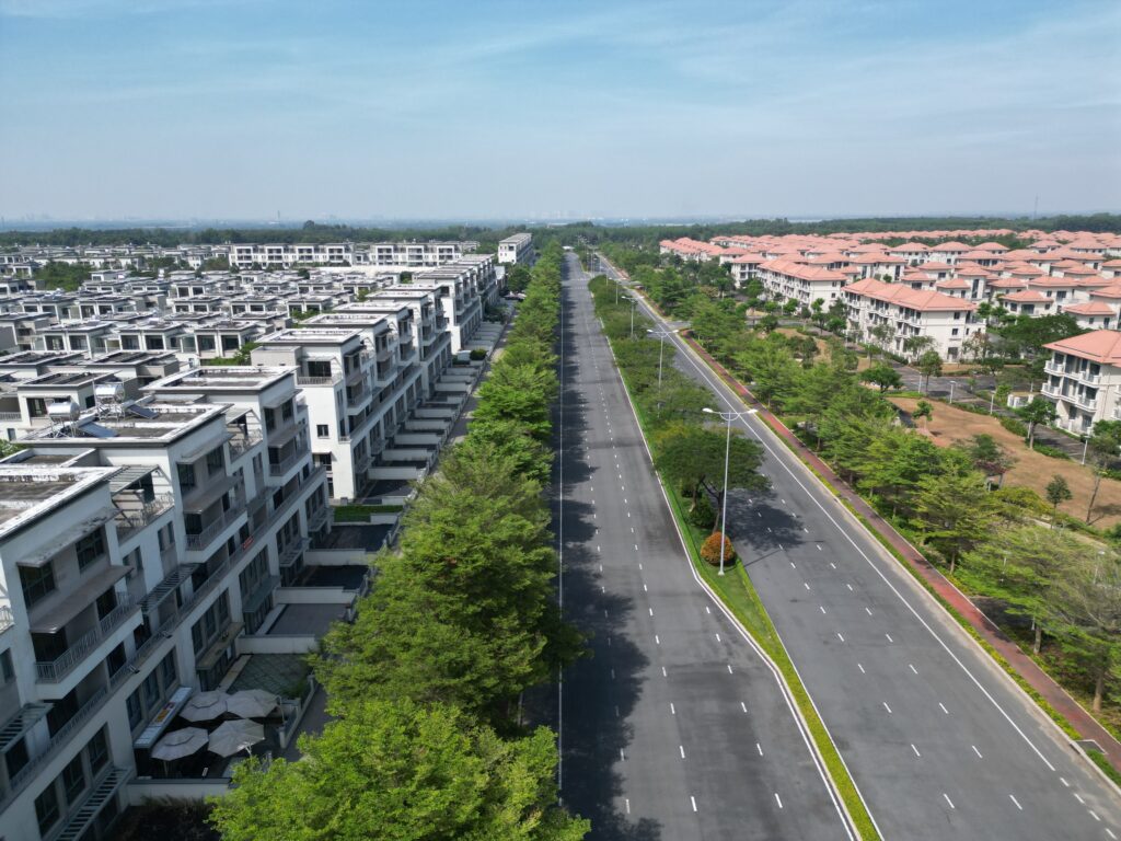 Aerial shot of a modern housing estate in Dong Nai, Vietnam, showcasing luxury homes and a wide road.